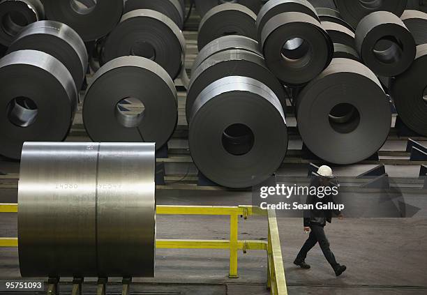 Worker walks by rolls of steel awaiting galvanization at the ThyssenKrupp steelworks on January 13, 2010 in Duisburg, Germany. Recent economic data,...