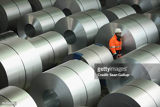 Worker, at the photographer's request, walks among finished rolls of galvanized steel at the ThyssenKrupp steelworks on January 13, 2010 in Duisburg,...