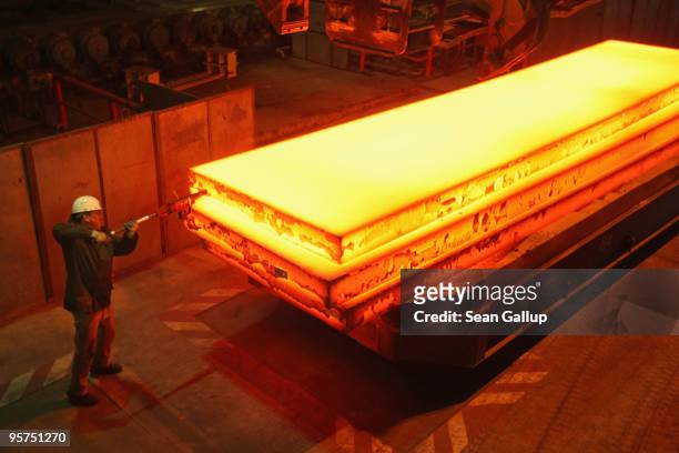 Worker tags a giant block of heated steel at the rolling mill at the ThyssenKrupp steelworks on January 13, 2010 in Duisburg, Germany. Recent...