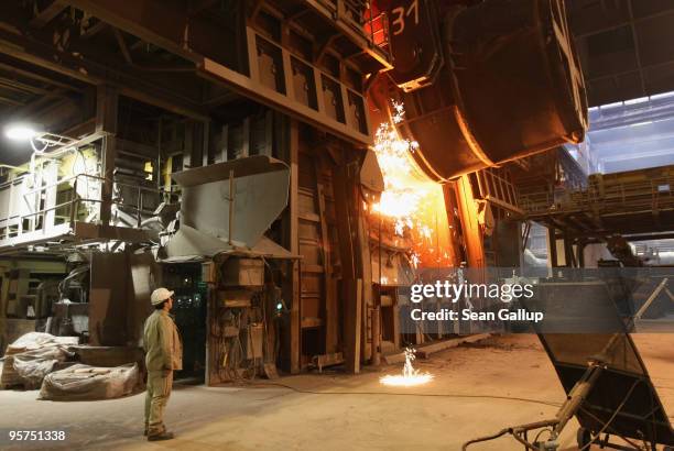 Worker watches as molten iron flows into a furnace for purification and alloying to become steel at the ThyssenKrupp steelworks on January 13, 2010...