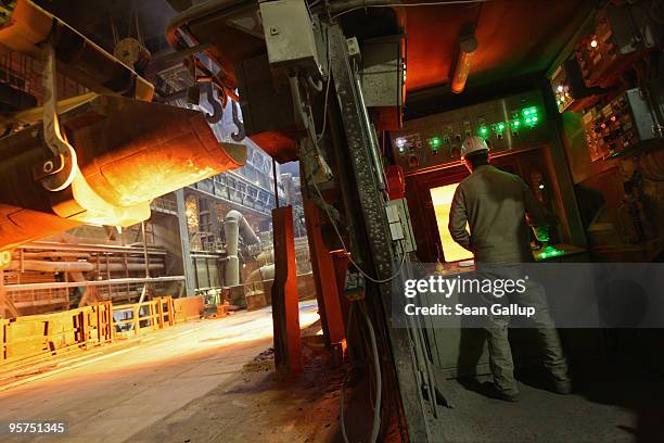 Worker oversees molten iron undergoing purification and alloying to become steel at the ThyssenKrupp steelworks on January 13, 2010 in Duisburg,...