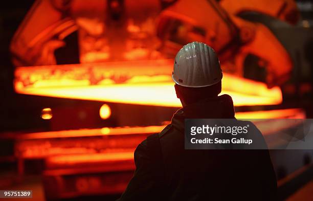 Worker uses a remote control to transport giant blocks of heated steel at the rolling mill at the ThyssenKrupp steelworks on January 13, 2010 in...