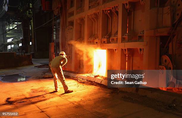 Worker oversees molten iron undergoing purification and alloying to become steel at the ThyssenKrupp steelworks on January 13, 2010 in Duisburg,...