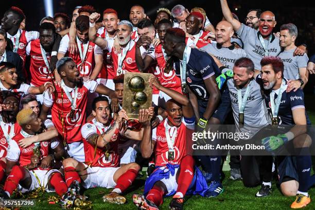 Reims players celebrate with the trophy after winning the French Ligue 2 match between Reims and Nimes at Stade Auguste Delaune on May 11, 2018 in...