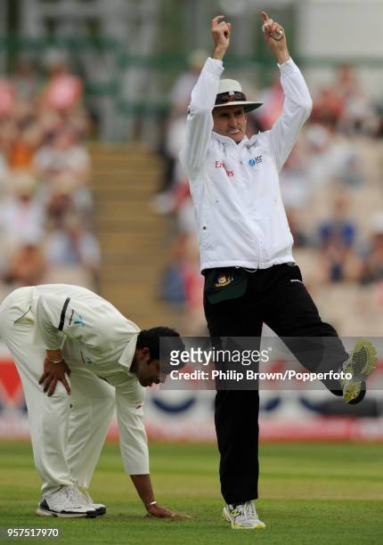 Umpire Billy Bowden signals a six as Bangladesh bowler Abdur Razzak dries his hands on the grass during the 2nd Test match between England and...