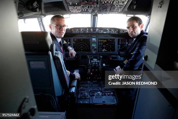 Pilots are pose inside the cockpit of a Boeing 737 MAX 8 as Boeing Commercial Airplanes, Qatar Airways and Air Italy celebrate the delivery of their...