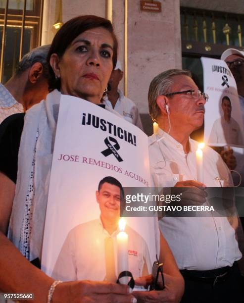 Members of the National Regeneration Movement Party lights candles during a protest following the murder of the party's mayoral candidate for the...