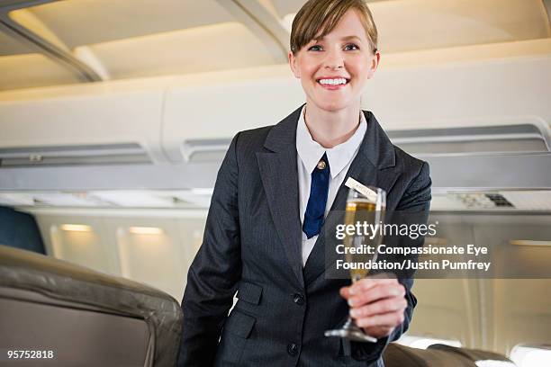 flight attendent holding glass  - compassionate eye foundation stock-fotos und bilder