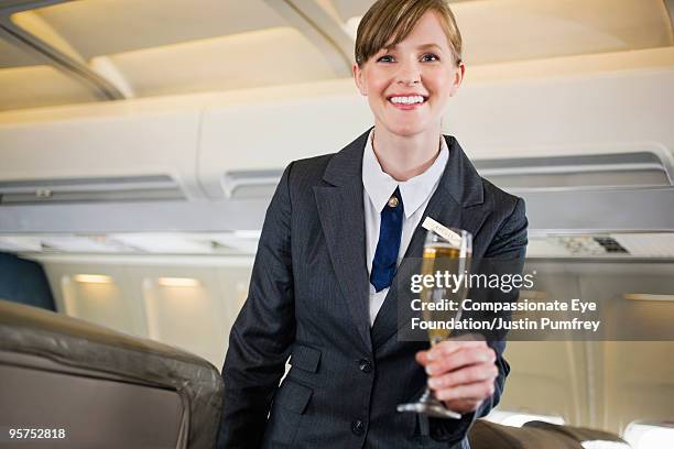 flight attendent holding glass  - compassionate eye foundation imagens e fotografias de stock