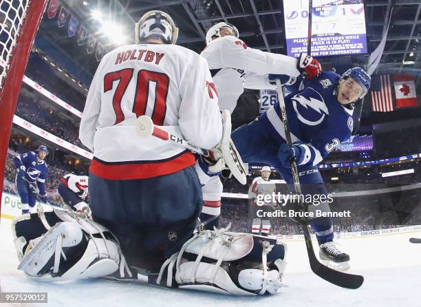 John Carlson of the Washington Capitals moves Yanni Gourde of the Tampa Bay Lightning from the crease in Game One of the Eastern Conference Finals...