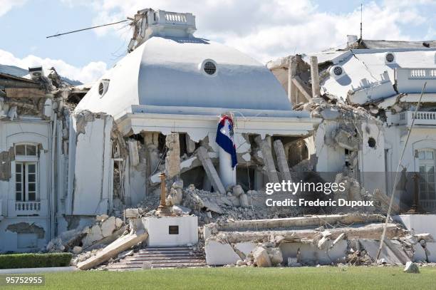 Haitian flag hangs on the ruins of the presidential palace January 13, 2010 in Port-au-Prince, Haiti. Planeloads of rescuers and relief supplies...