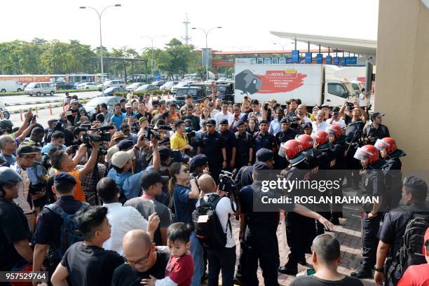 Malaysian Light Strike Force police stand guard as members of the media and public gather outside the Skypark terminal at Sultan Abdul Aziz Shah...