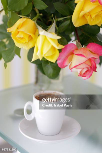 fresh roses and coffee cup on glass table - isabel pavia stockfoto's en -beelden