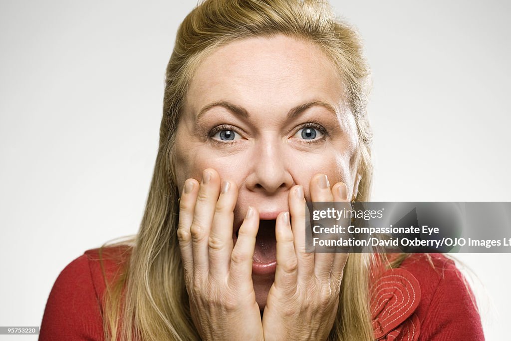 Woman holding her hands to her face