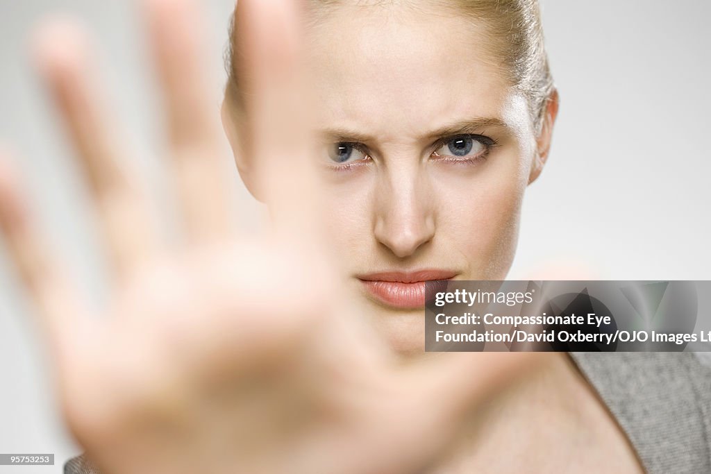 Woman partially blocking her face with her hand