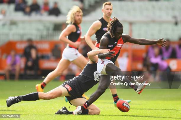 Anthony McDonald-Tipungwuti of the Bombers kicks whilst being tackled by Matthew Kreuzer of the Blues during the round eight AFL match between the...