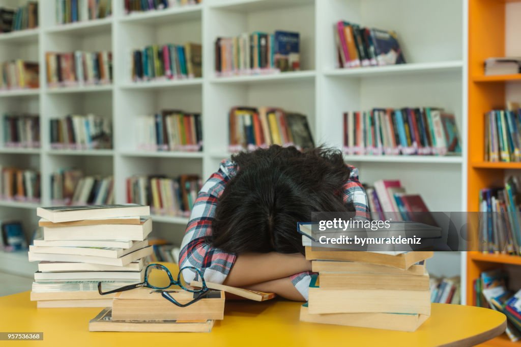 Student Sleeping on Books