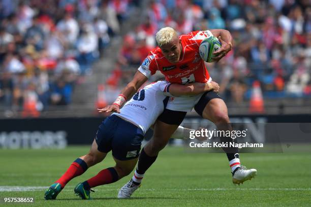 Hosea Saumaki of the Sunwolves is tackled by Jono Lance of the Reds during the Super Rugby match between Sunwolves and Reds at Prince Chichibu...