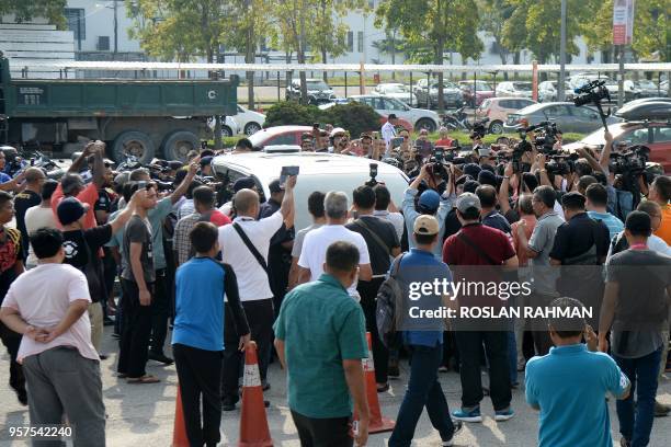 People crowd around a random white official car as it arrives at the Skypark terminal at Sultan Abdul Aziz Shah airport in Subang, suburban Kuala...