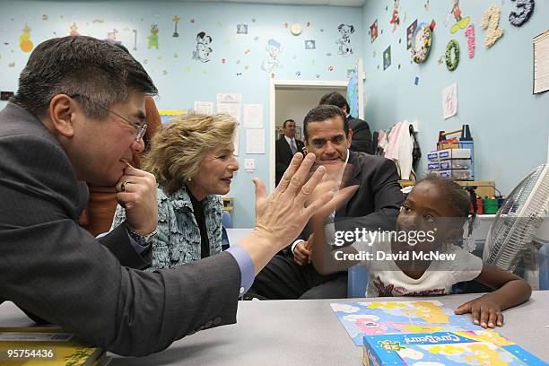 Commerce Secretary Gary Locke and four-year-old Kamora Bull exchange "hi-fives" as Sen. Barbara Boxer and Los Angeles Mayor Antonio Villaraigosa look...