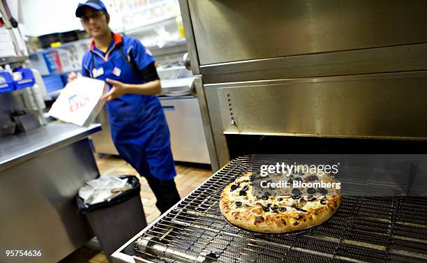 Shahla "Titly" Khan carries a box for a pizza exiting the oven at a Domino's Pizza franchise on 89th Street in New York, U.S., on Wednesday, Jan. 13,...