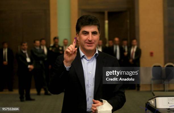 Prime Minister of Iraqi Kurdish Regional Government , Nechirvan Barzani shows his dye-stained finger with election ink following casting his vote for...