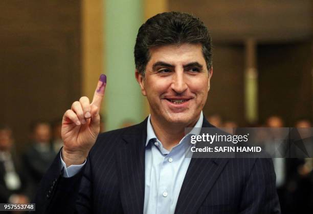Nechirvan Barzani, Prime Minister of Iraq's autonomous Kurdistan Regional Government , shows his ink-stained index finger at a polling station in the...