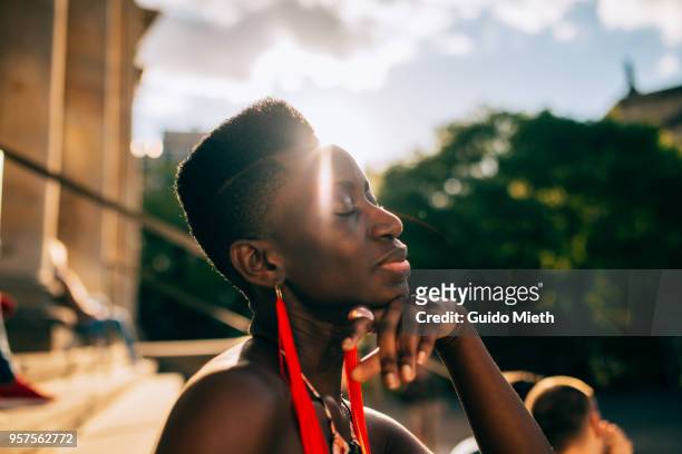 Young woman relaxing in the sun in the city.