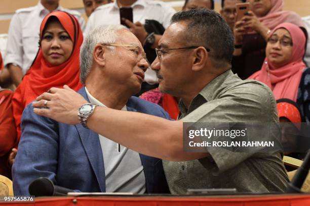 Former Malaysian prime minister Najib Razak is hugged by United Malays National Organisation senior leader Hishammuddin Hussein after Najib announced...