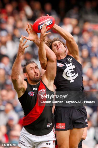 Charlie Curnow of the Blues marks in front of Cale Hooker of the Bombers during the round eight AFL match between the Carlton Blues and the Essendon...