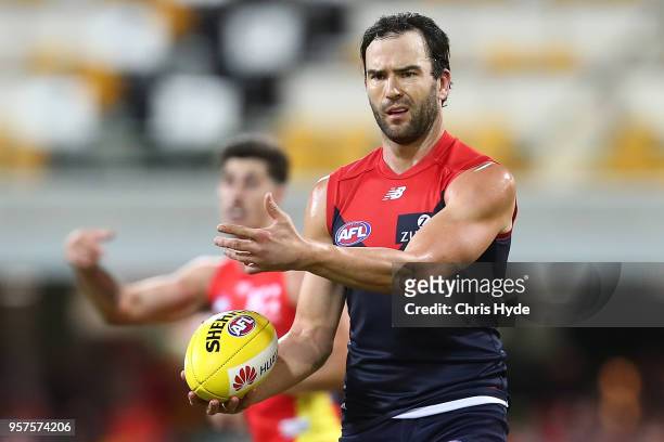 Jordan Lewis of the Demons handballs during the round eight AFL match between the Gold Coast Suns and the Melbourne Demons at The Gabba on May 12,...