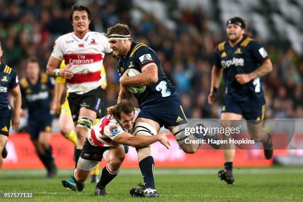 Luke Whitelock of the Highlanders is tackled by Nic Groom of the Lions during the round 12 Super Rugby match between the Highlanders and the Lions at...