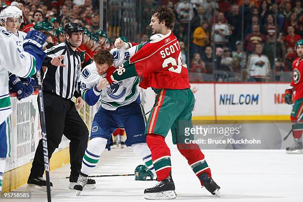 John Scott of the Minnesota Wild and Alexandre Bolduc of the Vancouver Canucks fight during the game at the Xcel Energy Center on January 13, 2010 in...
