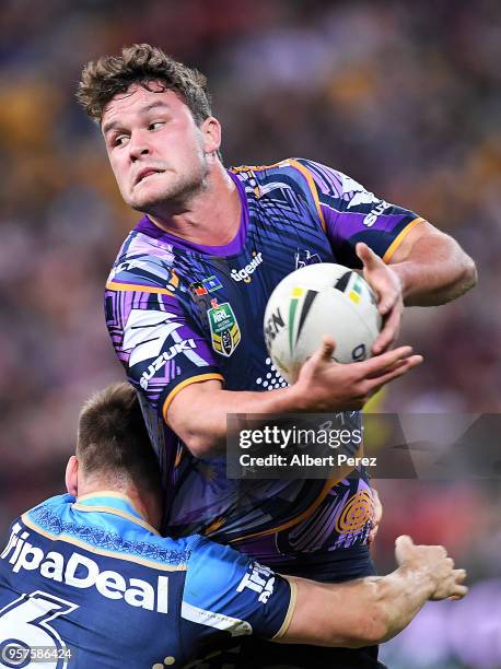 Joe Stimson of the Storm is tackled during the round ten NRL match between the Melbourne Storm and the Gold Coast Titans at Suncorp Stadium on May...