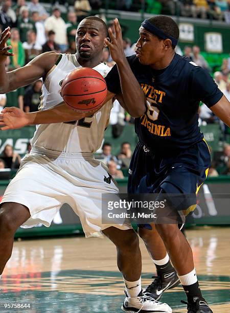 Toarlyn Fitzpatrick of the South Florida Bulls battles Kevin Jones of the West Virginia Mountaineers for a loose ball during the game at the SunDome...