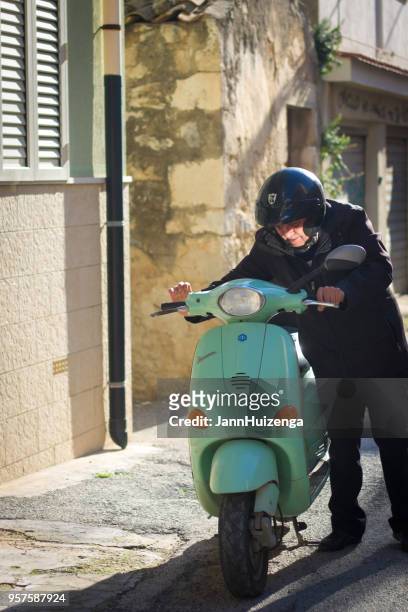 pozzallo, sicilia: senior hombre verde vintage vespa scooter - vespa brand name fotografías e imágenes de stock