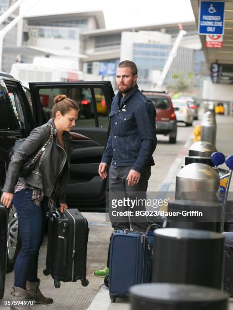 Stephen Amell and Cassandra Jean are seen at Los Angeles International Airport on May 11, 2018 in Los Angeles, California.