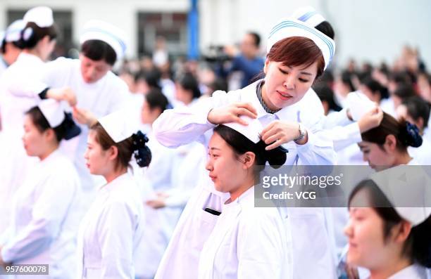 Nursing directors offer nurses caps to over 400 nursing students to celebrate the 107th International Nurses Day on the playground on May 11, 2018 in...