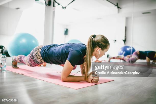 jonge vrouwelijke atleet in de plank pose running abs doen - plank exercise stockfoto's en -beelden
