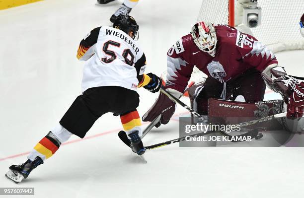 Latvia's goalkeeper Elvis Merzlikins stops Germany's Manuel Wiederer during the group B match Latvia vs Germany of the 2018 IIHF Ice Hockey World...