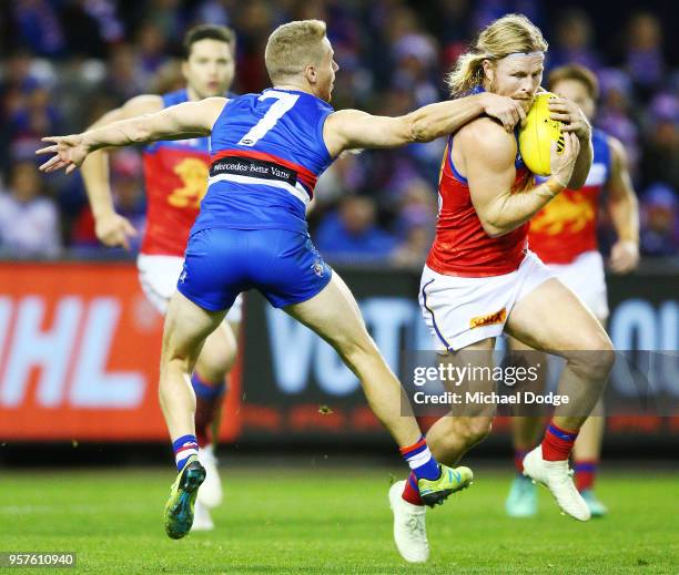 Lachie Hunter of the Bulldogs tackles Daniel Rich of the Lions during the round eight AFL match between the Western Bulldogs and the Brisbane Lions...