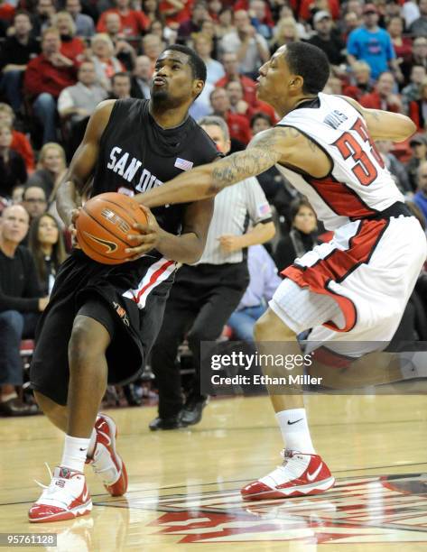 Chase Tapley of the San Diego State Aztecs is fouled by Tre'Von Willis of the UNLV Rebels during their game at the Thomas & Mack Center January 13,...