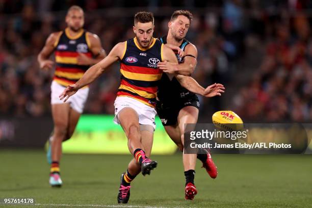 Myles Poholke of the Crows is tackled by Travis Boak of the Power during the 2018 AFL round eight match between the Port Adelaide Power and the...