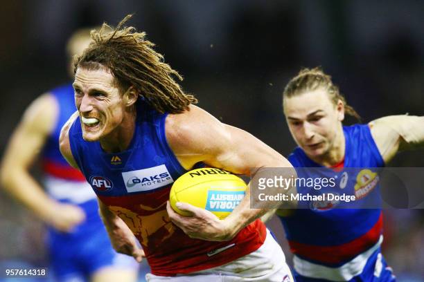 Matt Eagles of the Lions runs with the ball from Mitch Honeychurch of the Bulldogs during the round eight AFL match between the Western Bulldogs and...