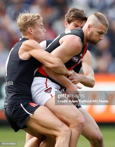 Jake Stringer of the Bombers is tackled by Sam Kerridge and Paddy Dow of the Blues during the 2018 AFL round eight match between the Carlton Blues...