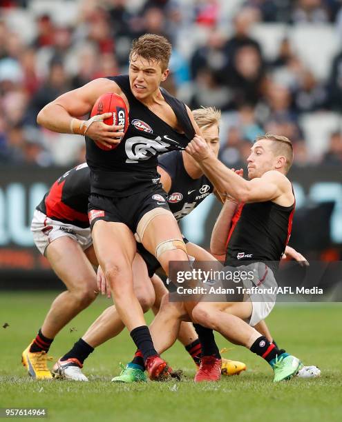 Patrick Cripps of the Blues is tackled by Devon Smith of the Bombers during the 2018 AFL round eight match between the Carlton Blues and the Essendon...