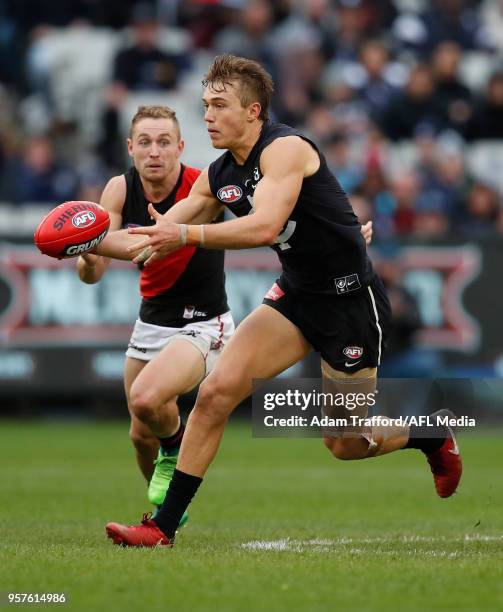 Patrick Cripps of the Blues in action ahead of Devon Smith of the Bombers during the 2018 AFL round eight match between the Carlton Blues and the...