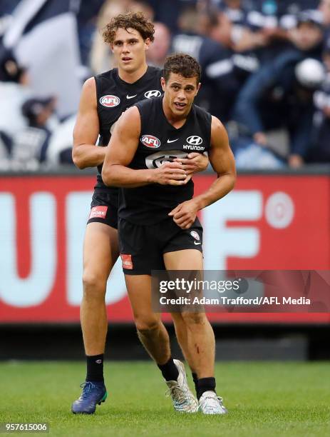 Charlie Curnow of the Blues helps up his brother Ed Curnow of the Blues during the 2018 AFL round eight match between the Carlton Blues and the...