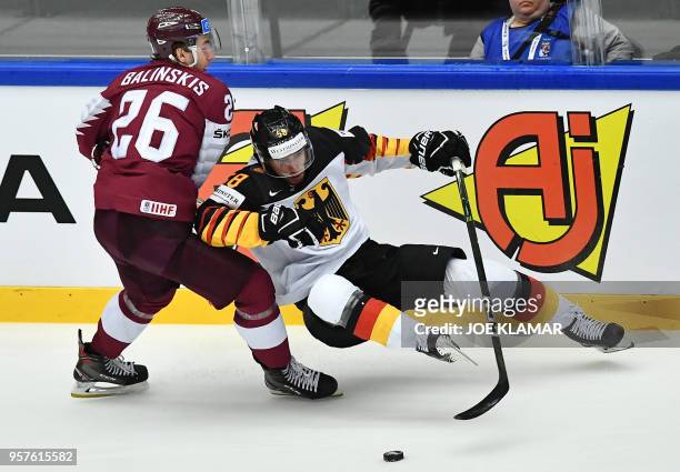 Latvia's Uvis Balinskis challenges for the puck with Germany's Markus Eisenschmid during the group B match Latvia vs Germany of the 2018 IIHF Ice...