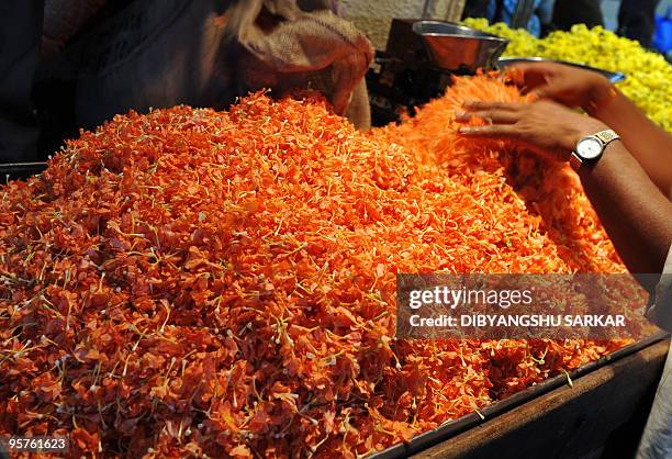 Indian vendors sell flowers for the celebration of the festival of Pongal, at the main wholesale market in Bangalore, on January 14, 2010. Pongal is...